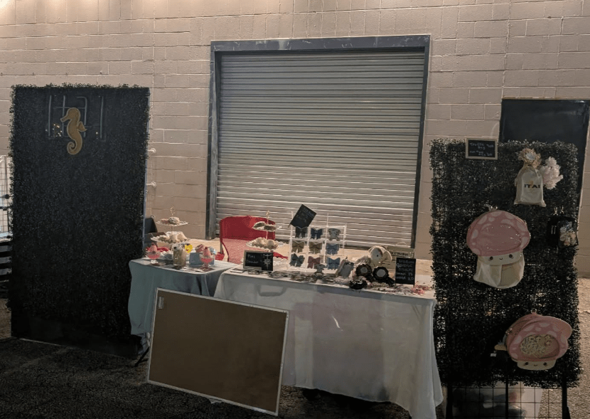 the ITAI booth set up for Nana Anime Night. The booth features a display of ITA bags, rosettes, and other kawaii accessories. 